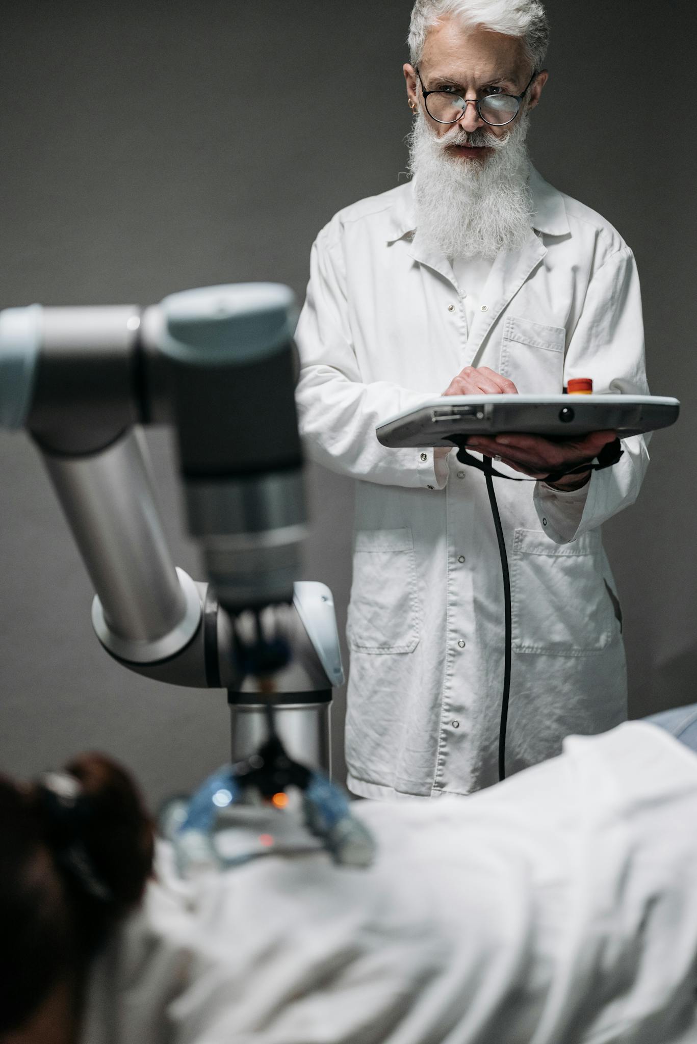 Scientist in a white coat operating a robotic arm in a modern laboratory environment.